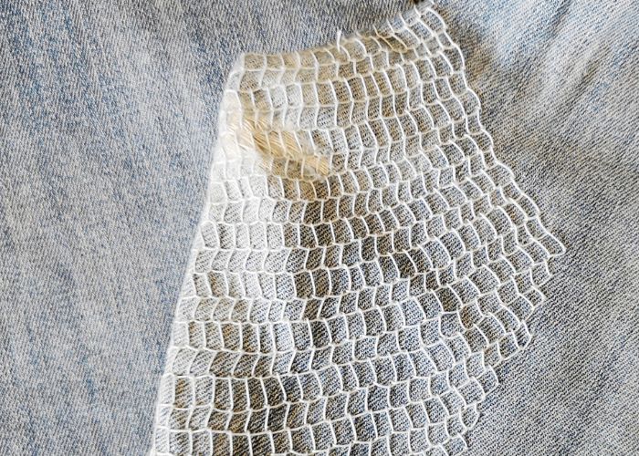 Jeans mended with Blanket stitch filling