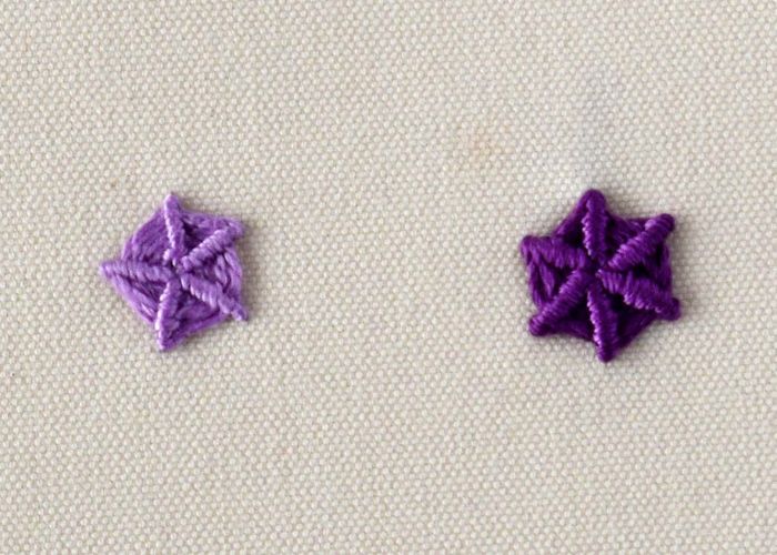 Broderie de la roue d'araignée fouettée avec des fils violets