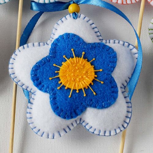 Flor de fieltro azul, amarilla y blanca