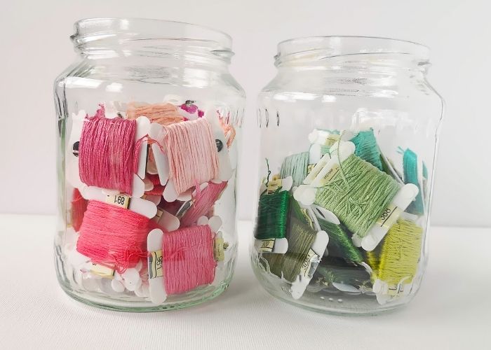 Embroidery Threads organization : Embroidery floss on bobbins stored in glass jars